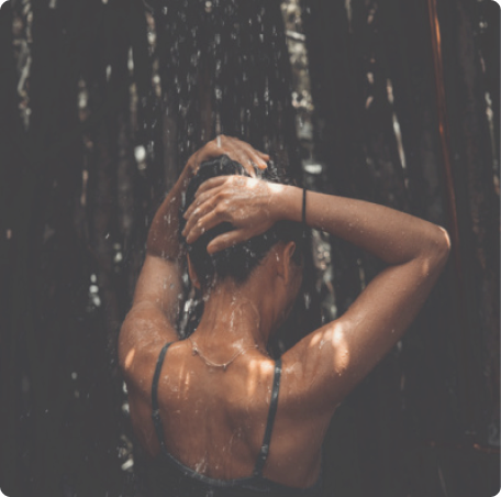 Vrouw onder de douche die haar haar wast